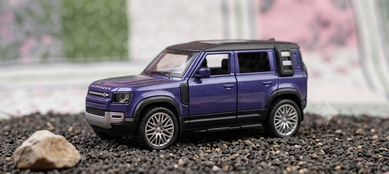 Land Rover Defender Diecast on gravel – side view